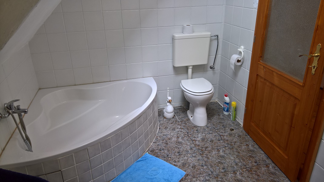 Koupelna v podkroví je vybavena umyvadlem, vanou, toaletou a pračkou