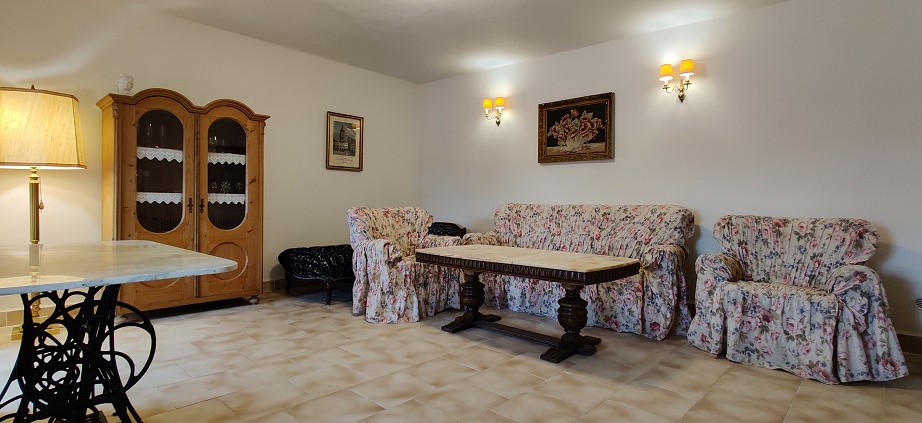Společenská místnost s pohovkou, otomanem a televizí